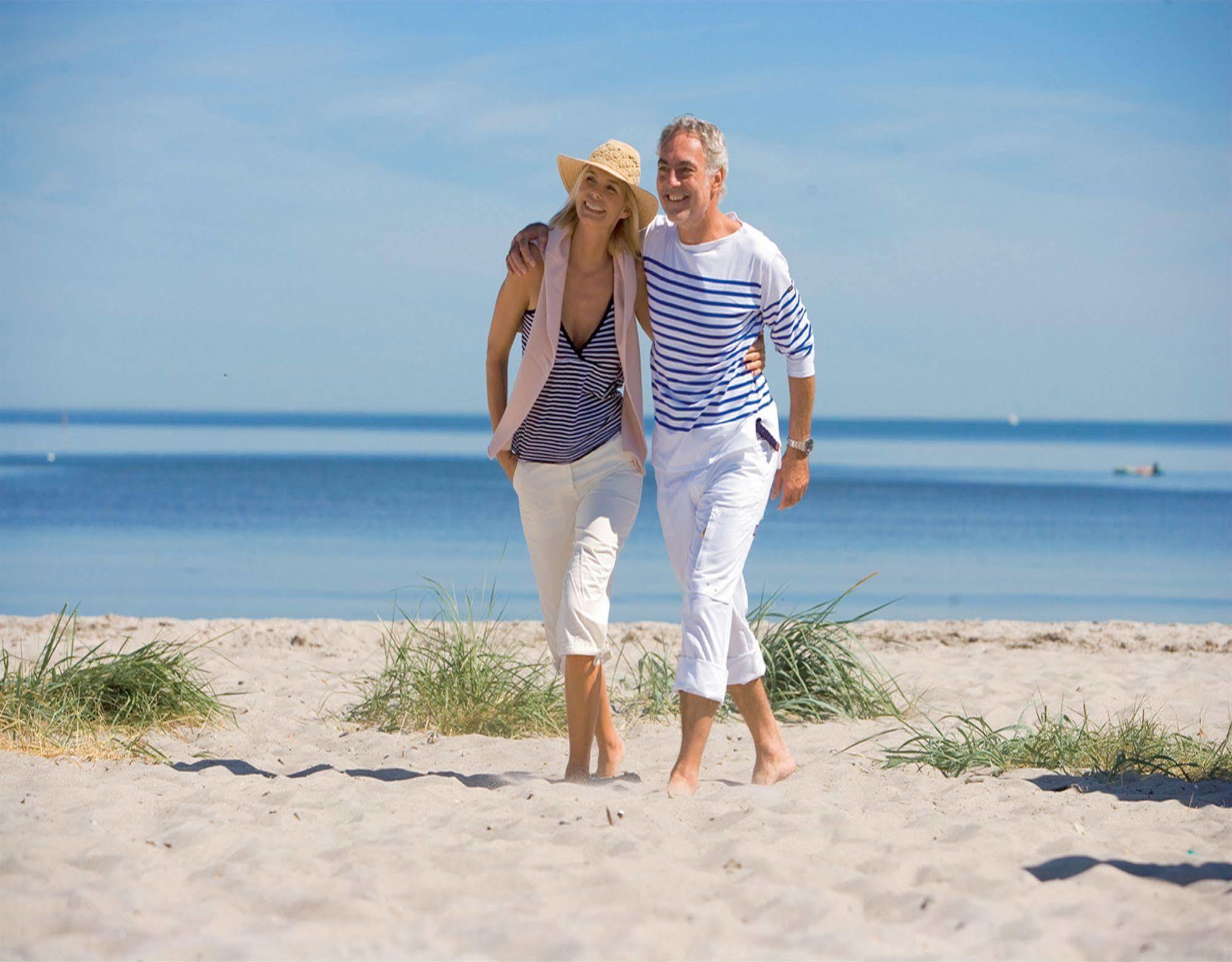 Yachthafenresidenz Hohe Duene Hotel Rostock Exterior photo A couple walking on the beach